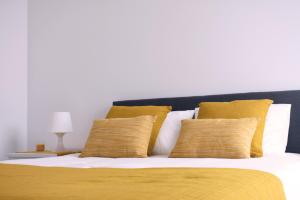 ポンタ・デルガダにあるAzores Sea Viewのベッド(黄色と白の枕付)