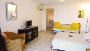 a room with two beds and a tv and chairs at Villa Ghiatone in Pietrosella