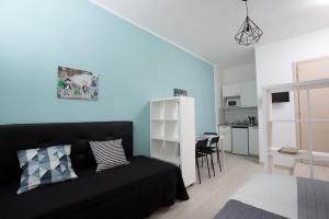 a living room with a black couch and a kitchen at Rimini Youth Apartment in Rimini