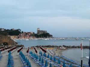 una spiaggia con sedie e ombrelloni e un castello di Rivamare San Terenzo a Lerici