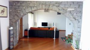 a living room with a stone wall and a couch at Sea View House in Ribeira Brava
