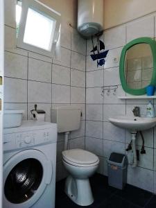 een badkamer met een wasmachine en een wastafel bij Blue Holidays Apartment in Šibenik
