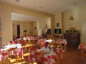 un comedor con mesas y sillas con manteles rojos y blancos en Hotel Richelieu, en Eaux-Bonnes