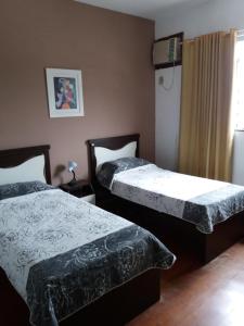 dos camas sentadas una al lado de la otra en un dormitorio en Penthouse Botafogo Rio de Janeiro en Río de Janeiro