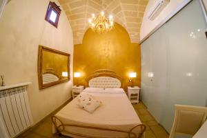 1 dormitorio con cama y lámpara de araña en Palazzo Aurora, en Alezio