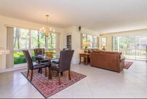 a living room with a table and chairs and a couch at PGA National Resort Golf Villa - Luxurious Two Bedroom First Floor Water View in Palm Beach Gardens