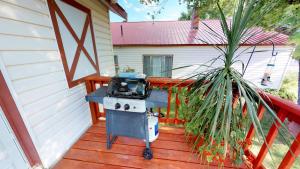a grill on a deck next to a house at Hot Tub, Kokopelli Kabyn, Cute and Cozy! in Blanding