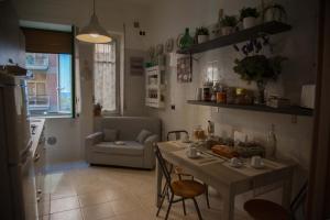 サレルノにあるSalerno Centraal Apartmentのキッチン、リビングルーム(テーブル、ソファ付)