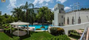 a swimming pool with a gazebo next to a building at The Lorian Club in Cocoyoc