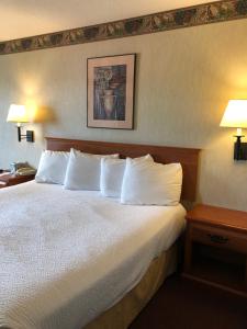 Habitación de hotel con cama con almohadas blancas en The Ashley Inn of Tillamook, en Tillamook