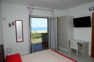 a bedroom with a bed and a table and a balcony at B&B Torre Nave in Praia a Mare