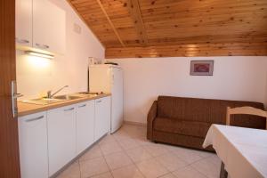 a kitchen with a refrigerator and a couch in a room at Rooms Sofija in Selce