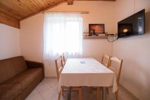 a dining room with a table and a couch at Rooms Sofija in Selce