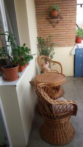 a patio with two wicker chairs and potted plants at Apartament cu 2 camere in Călimăneşti