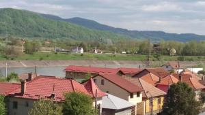 a village with red roofs and a river at Apartament cu 2 camere in Călimăneşti