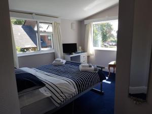 Un pat sau paturi într-o cameră la Alexandra Lodge Guest House