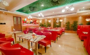 a restaurant with red chairs and tables in a room at Divinity by Audra Hotels in Mathura