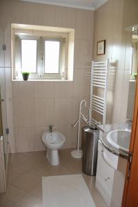 baño con aseo y lavabo y ventana en 'Casa do Afonso', en Esposende