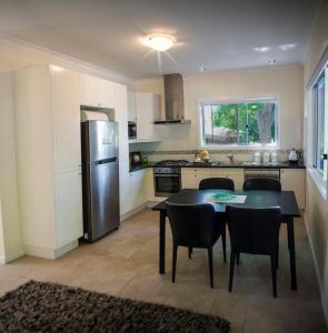 a kitchen with a table and chairs and a refrigerator at Farview Guest Accommodation in Pickering Brook