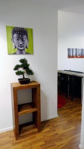 a plant on a wooden stand in a room with a picture at KR studio apartment Harju in Helsinki