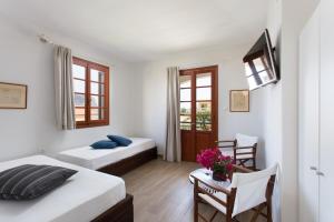 Un dormitorio con 2 camas y una mesa con flores. en Venetia Apartments, en Monemvasia