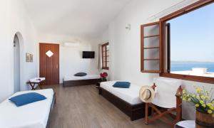 a hotel room with two beds and a window at Venetia Apartments in Monemvasia