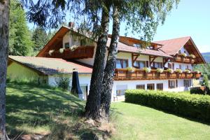 a large white house with a balcony and trees at GarniHotel - Arberblick in Lohberg