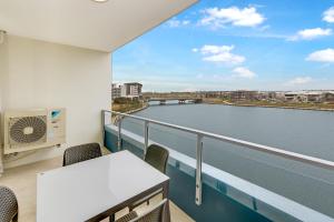 a balcony with a table and chairs and a view of a river at Aquarius Kawana in Kawana Waters
