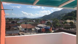 een uitzicht vanuit het raam op een stad met bergen bij Recanto Duas Peras in Caraguatatuba