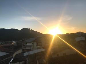 een uitzicht op de zonsondergang boven een stad bij Recanto Duas Peras in Caraguatatuba