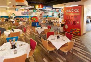 a restaurant with tables and chairs and aride book at LEGOLAND California Hotel and Castle Hotel in Carlsbad