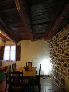 jadalnia ze stołem i kamienną ścianą w obiekcie Mas de Muñoz w mieście Mora de Rubielos