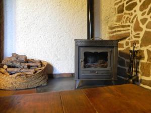 Una chimenea en una habitación con una pared de piedra. en Mas de Muñoz, en Mora de Rubielos