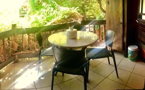 une table et des chaises sur un balcon avec une tasse dessus dans l'établissement Vilarejo Do Farol, Praia do Forte, à Praia do Forte