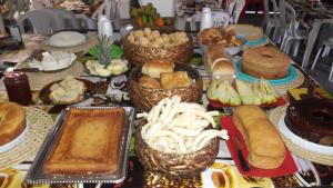 a table topped with lots of different types of food at Pousada e Hostel Monalisa in São Thomé das Letras