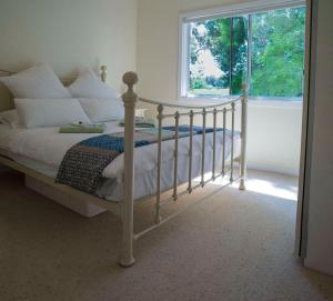 a white bed in a bedroom with a window at Farview Guest Accommodation in Pickering Brook