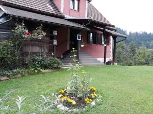 una casa con un mazzo di fiori in giardino di Apartman Anika a Moravice