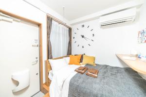 1 dormitorio con 1 cama con reloj en la pared en Maison de Takinogawa, en Tokio