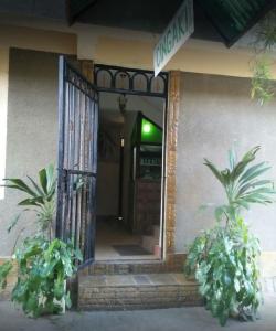 an open door of a house with two potted plants at Cingaki Hotel in Mombasa