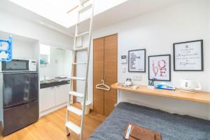 Habitación con escalera y cocina con nevera. en Maison de Takinogawa, en Tokio