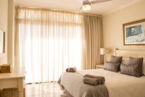 een slaapkamer met een groot bed en een groot raam bij 207 Terra Mare - by Stay in Umhlanga in Durban