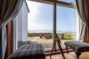 HallinにあるDunhallin Ardの海の景色を望む大きな窓が備わる客室です。