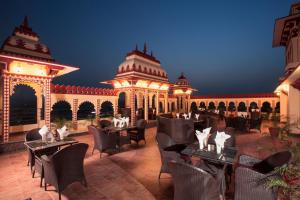 ein Restaurant mit Tischen und Stühlen vor einem Gebäude in der Unterkunft Umaid Haveli-A Heritage Style Hotel & Resort in Jaipur