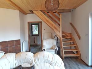 a living room with two chairs and a staircase at Chata OSTRUZINA 9 in Lipno nad Vltavou