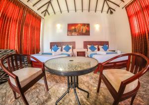 Pokój z 2 łóżkami, stołem i krzesłami w obiekcie White Rose Beach Resort w mieście Marawila