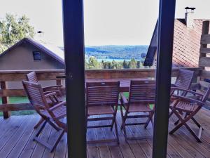 a porch with chairs and a table on a deck at Chata OSTRUZINA 9 in Lipno nad Vltavou