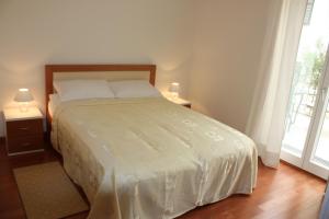 a bedroom with a bed with two lamps and a window at Villa Mare Crikvenica in Crikvenica