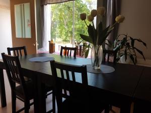 a dining room table with a vase of flowers on it at Nalles Gästhem in Eckerö