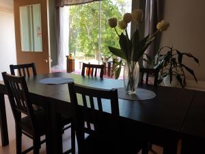 - une table à manger avec un vase de fleurs dans l'établissement Nalles Gästhem, à Eckerö