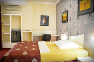 a hotel room with a bed and a desk at Pension Yellow in Timişoara